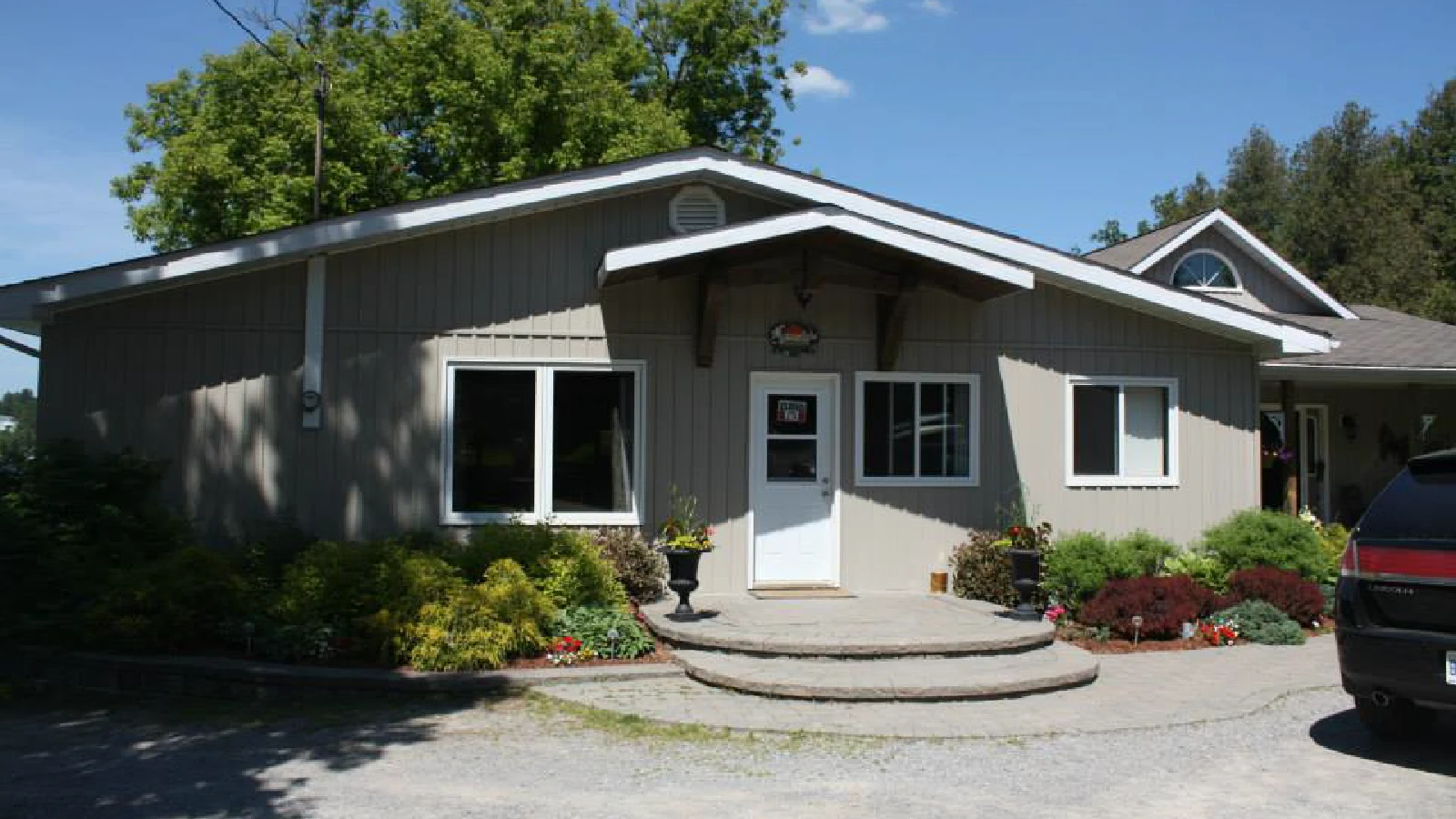 Pigeon Lake Cottages office and store exterior with entrance, landscaping, and parking area